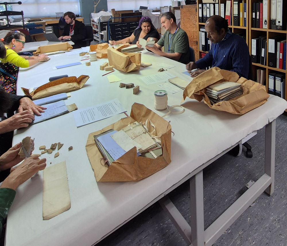 C4W_Conservation for Wellbeing participants, a Stuart Low Trust volunteer and staff cleaning documents at The London Archives.jpg